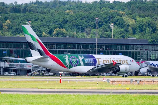 Emerates airplane on runway branded with Wimbledon 2025 graphics